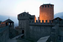 Entrance and drawbridge of Bellinzona city wall illuminated at night — Stock Photo