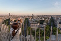 Mujer fotografiando vista, La Torre Eiffel y el skyline de París, Fr. - foto de stock