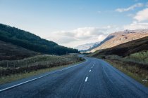 Открытая извилистая дорога в горах, Шотландия, Великобритания — стоковое фото