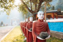 Row of buddhist monk statues holding ban bats, Kaw Ka Thawng Cav — Stock Photo