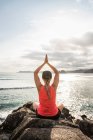 Touristin praktiziert Yoga auf Felsen, Mawi Beach, Lombok, Indonesien — Stockfoto