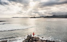 Tourist looking out on cliff, Mawi Beach, Lombok, Indonesia — Stock Photo