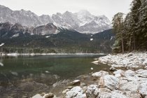 Lago Eibsee y montañas en la nieve, Zugspitze, Baviera, Alemania - foto de stock