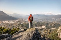 Uomo in piedi sulla montagna, guardando la vista, Stawamus Capo, overl — Foto stock