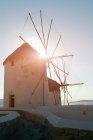 Zwei traditionelle, sonnenbeschienene Windmühlen an der Küste, Mykonos, Kykladen, Gr — Stockfoto