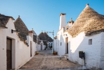 Ruelle pavée avec maisons de trullo blanchies à la chaux, Alberobello, Pouilles, — Photo de stock