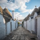 Callejón pavimentado con casas trullo encaladas, Alberobello, Puglia, - foto de stock