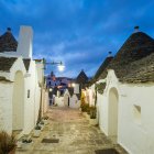 На сутінках (провінція Альберобелло) стоять будинки з білосніжними сплавами та білим пранням., — стокове фото