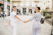 Young lesbian couple walking down a street, holding hands. — Stock Photo