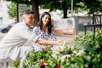 Giovane coppia lesbica in piedi al mercato bancarella, guardando le piante — Foto stock