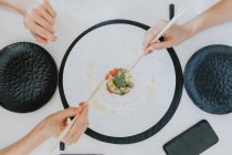 Großaufnahme von zwei Frauen, die an einem Tisch sitzen und Sushi essen. — Stockfoto
