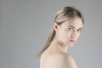 Nude young woman on grey background — Stock Photo