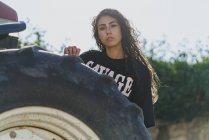 Junge Frau hinter Traktorreifen — Stockfoto