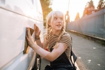 Jovem mulher usando lixa em sua van — Fotografia de Stock