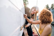 Young female couple working on their van — Stock Photo