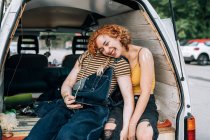 Happy lesbian couple, sitting in back of van — Stock Photo