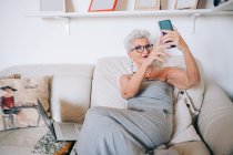 Mulher fazendo videochamada no telefone em casa — Fotografia de Stock