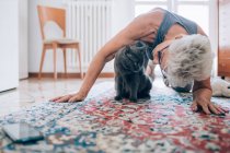 Пожилая женщина с домашним котом на полу — стоковое фото