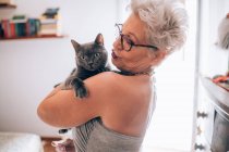 Mujer sosteniendo su gato mascota - foto de stock