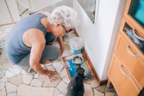 Frau gibt ihrer Katze Futter — Stockfoto