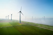 Turbinas eólicas marinas situadas en la niebla del interior de IJsselmeer - foto de stock