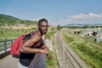Young man on bridge by railway track — Stock Photo