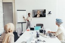 Geschäftsfrau hält Vortrag vor Kollegen in Amt und Würden — Stockfoto