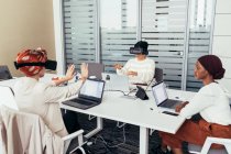 Colegas usando fones de ouvido de realidade virtual no escritório — Fotografia de Stock
