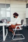 Geschäftsfrau trägt Gesichtsmaske, arbeitet im Büro — Stockfoto
