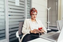 Geschäftsfrau nutzt Smartphone im Büro — Stockfoto