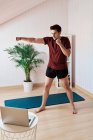 Homem seguindo aula de exercícios online, movimento de soco — Fotografia de Stock