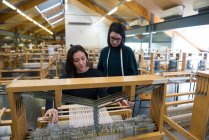 Studenten weben mit Webstuhl in Textilwerkstatt — Stockfoto