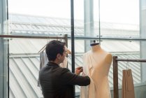 Модный студент, работающий над одеждой на манекене — стоковое фото