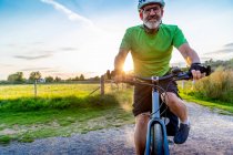 Mature man mountain biking in countryside — Stock Photo
