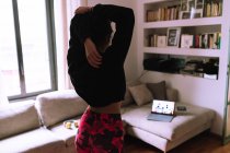 Женщина растяжения, следующие онлайн упражнения класса — стоковое фото