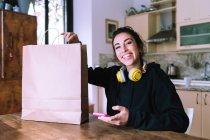 Девушка с покупкой в коричневом бумажном пакете — стоковое фото
