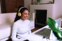 Молода жінка на відеозв'язку на ноутбуці, сміється — стокове фото