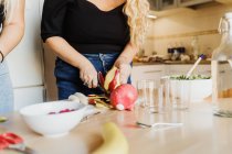 Женщина готовит фрукты, обрезанный вид — стоковое фото