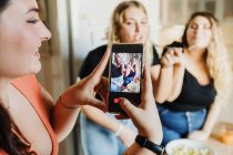 Жінка знімає відео своїх друзів, які їдять — стокове фото