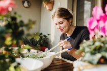 Young woman serving salad — Stock Photo