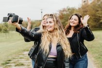 Amigos tirando selfie com câmera — Fotografia de Stock