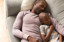 Pai e filho dormindo no sofá — Fotografia de Stock