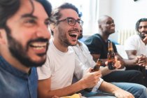 Mann trinkt Bier und schaut gemeinsam fern, lacht — Stockfoto