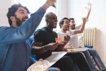 Men eating pizza and cheering — Stock Photo