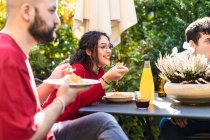Amigos comendo refeição juntos ao ar livre — Fotografia de Stock