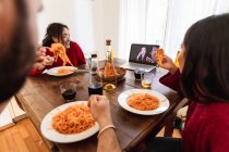 Friends having spaghetti meal and making video call — Stock Photo