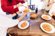 Друзі діляться спагеті їжею і мають відеодзвінок — стокове фото