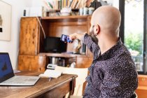 Young man working at home, having video call on phone — Stock Photo