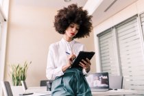 Businesswoman making notes on tablet — Stock Photo