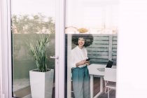 Donna d'affari sorridente, guardando attraverso la finestra — Foto stock